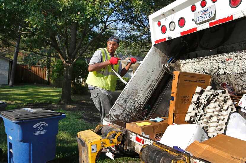 Sanitation worker Markeese Griggs works to empty trash cans in East Dallas. The contractor...