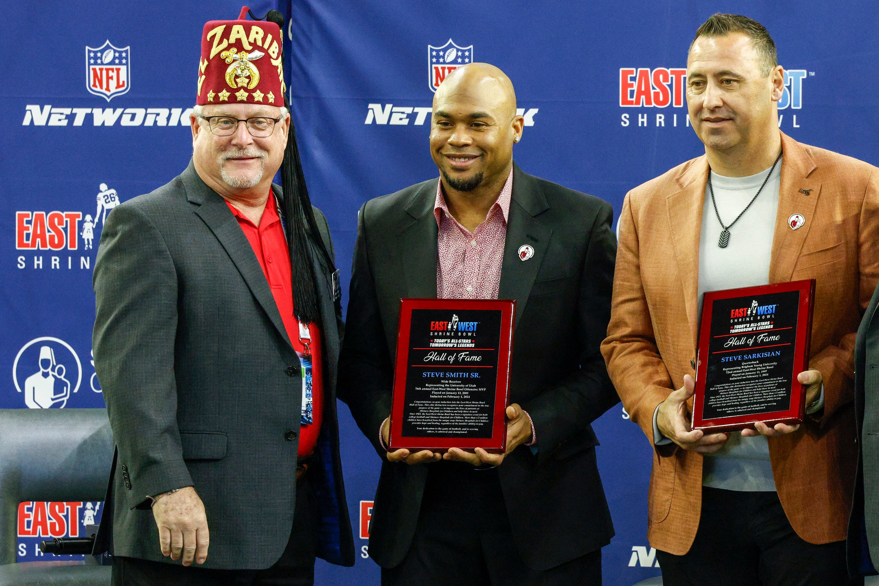 Ed Stolze from Imperial Sirs (left) presents East-West Shrine Bowl Hall of Fame plaques to...