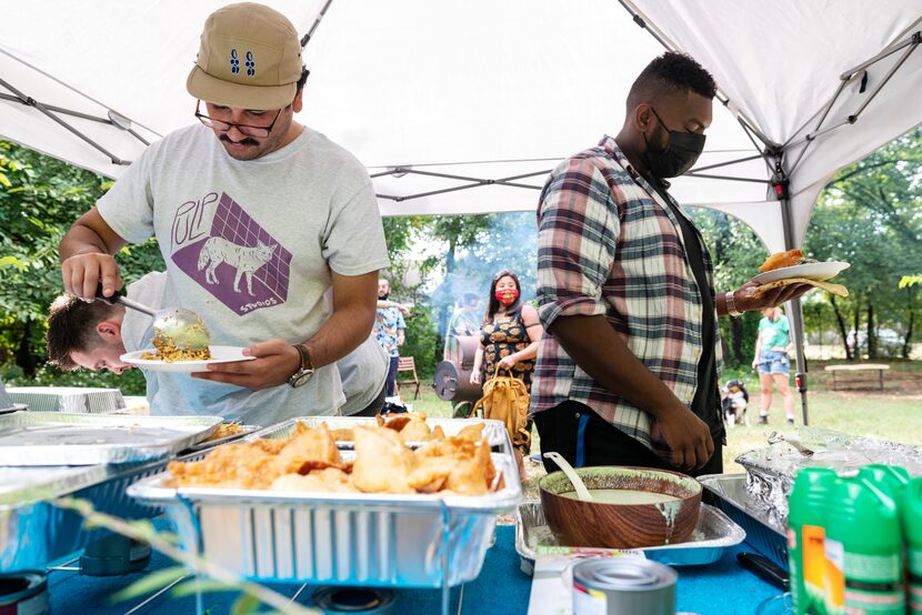 Daniel F., 28, left, and Abdelhalim Awadalla, 28, serve themselves food during a PunjabiTex...