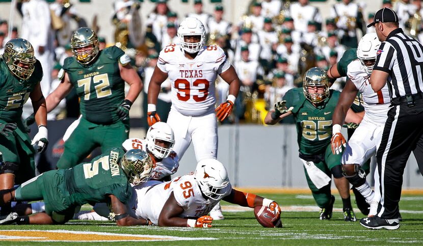 Texas defensive tackle Poona Ford (95) recovers a fumble by Baylor running back Johnny...