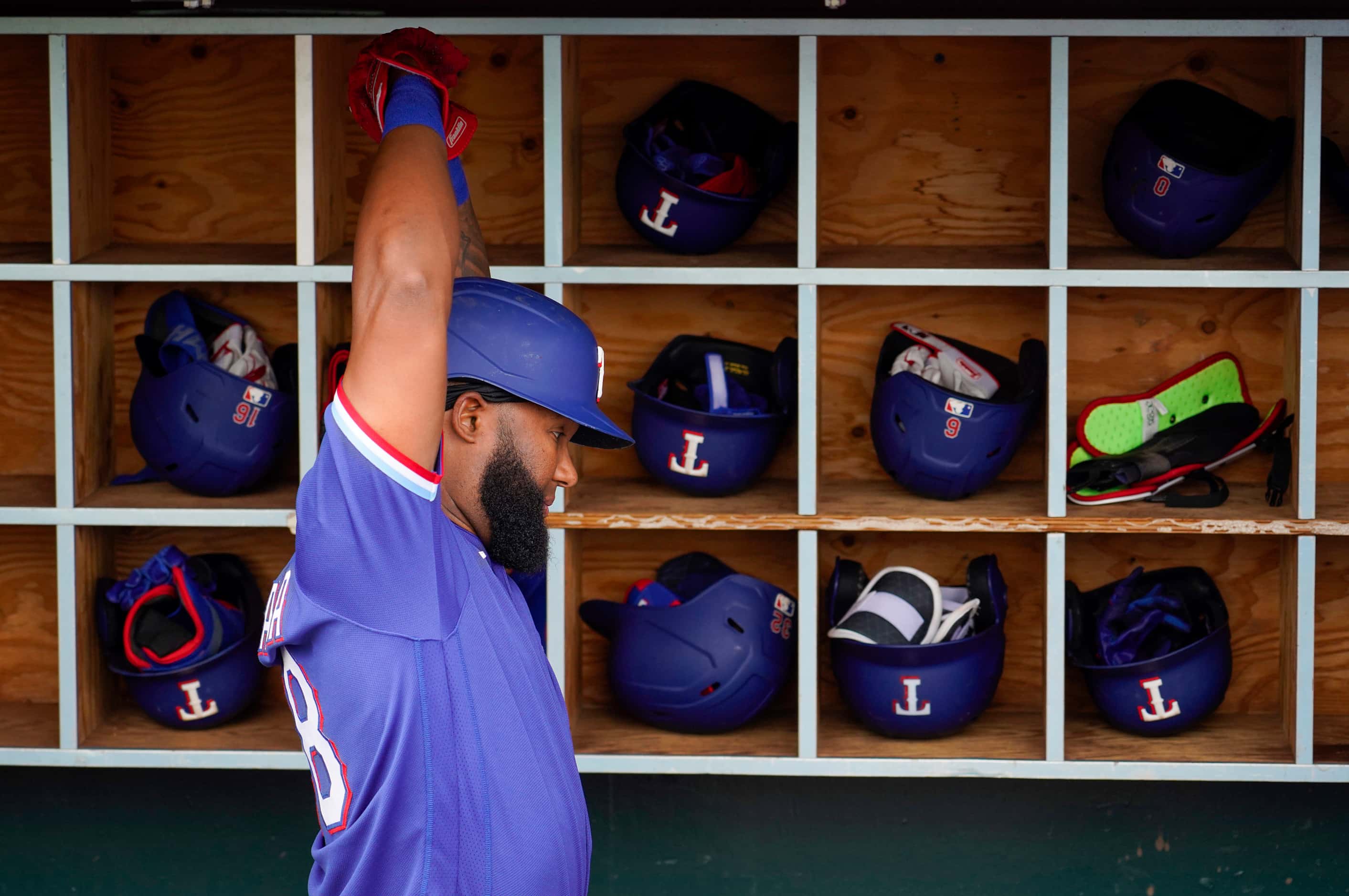 Texas Rangers outfielder Danny Santana stretches in the dugout before a spring training game...