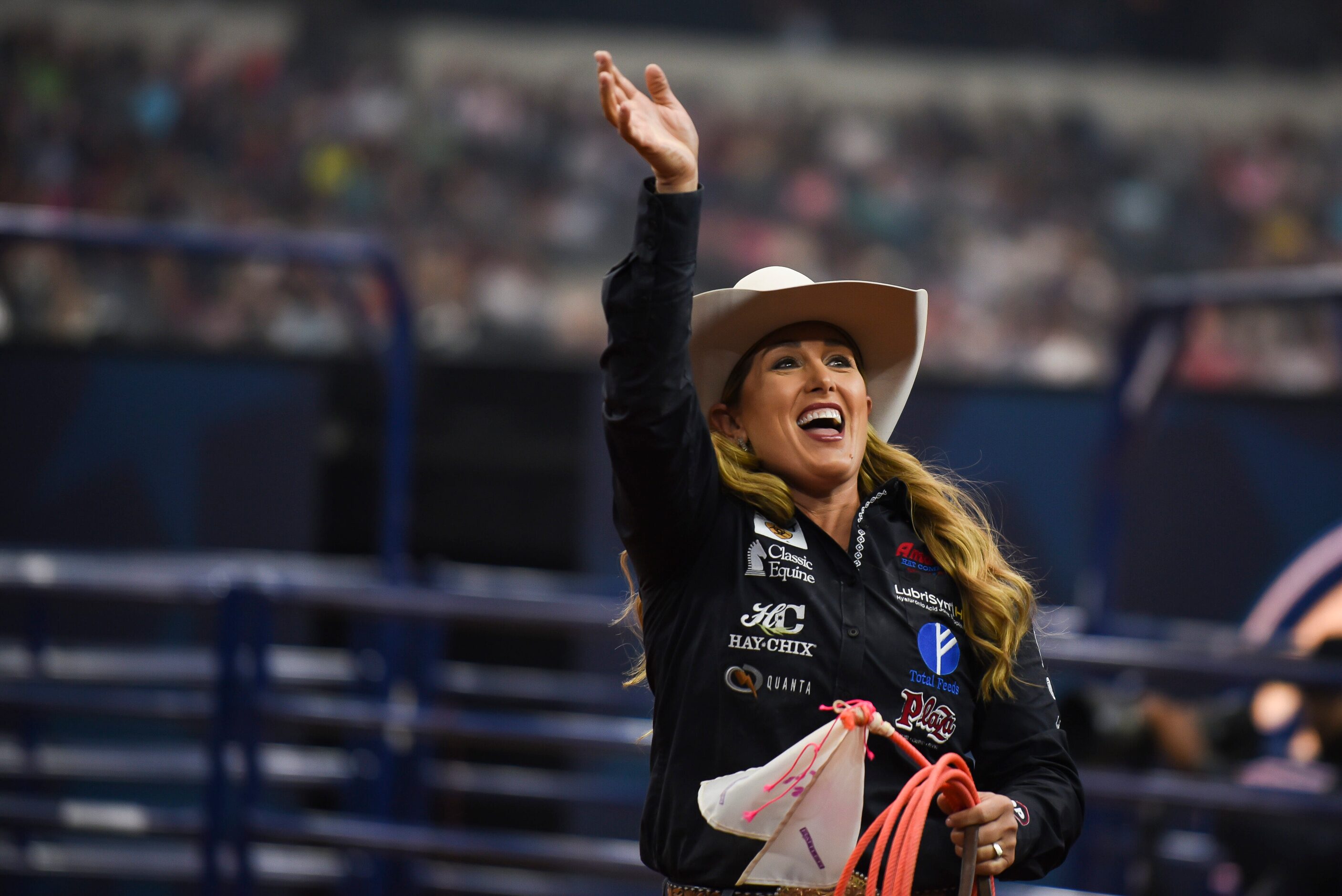 Jackie Crawford waves at fans in the crowd after winning the Breakaway Roping event during...