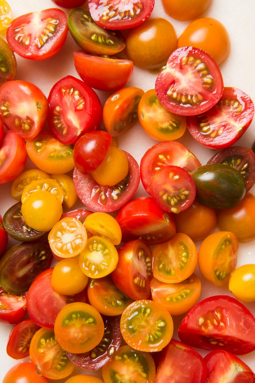 Sliced cherry tomatoes in red, orange, yellow and green