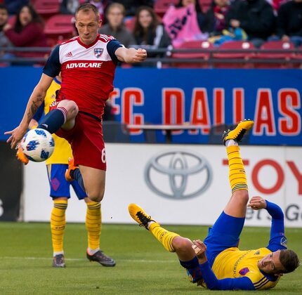 FC Dallas defender Anton Nedyalkov (6) shoots over fallen Colorado Rapids defender Deklan...