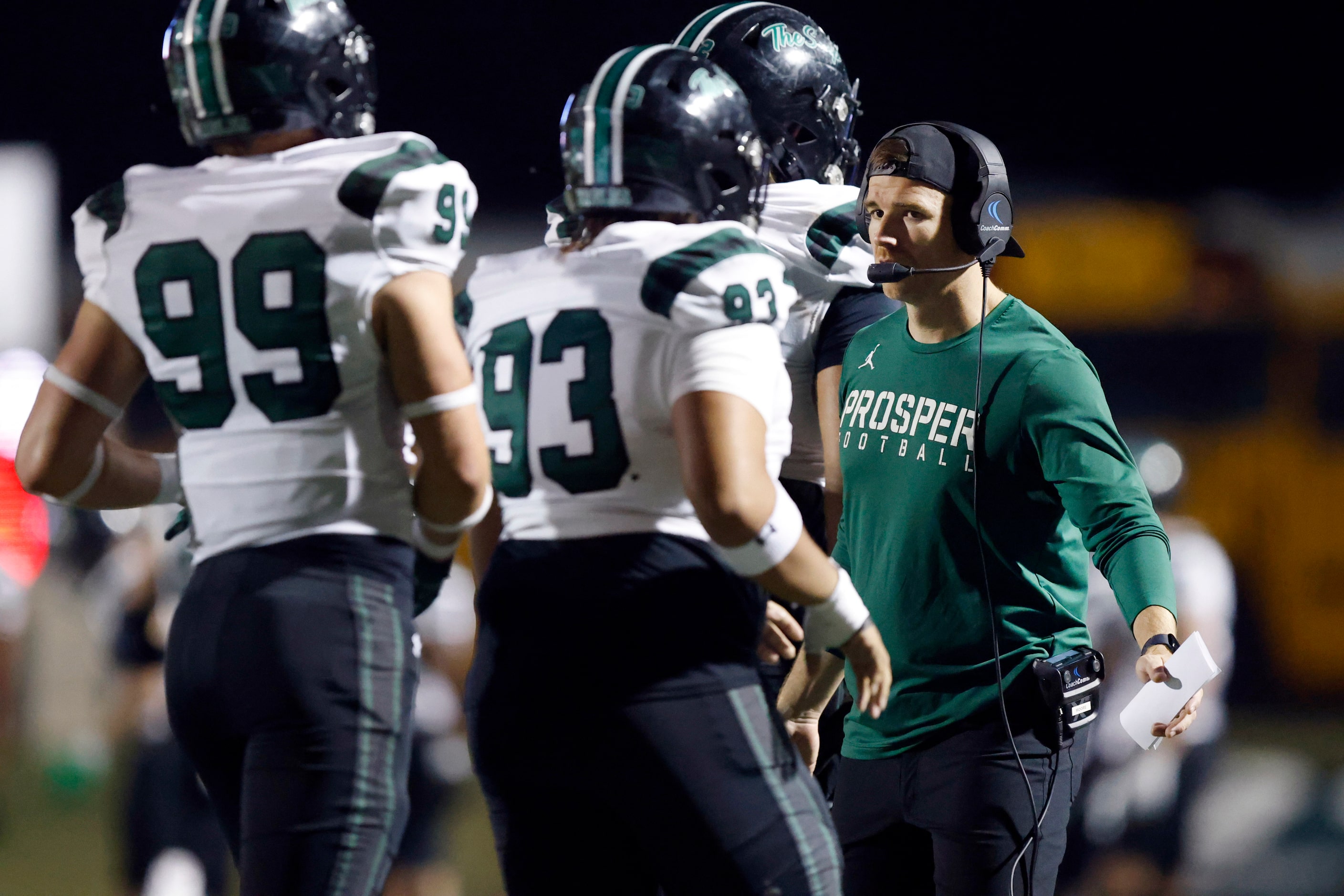 Prosper High head football coach Tyler Moore  slaps hands with his players following a...