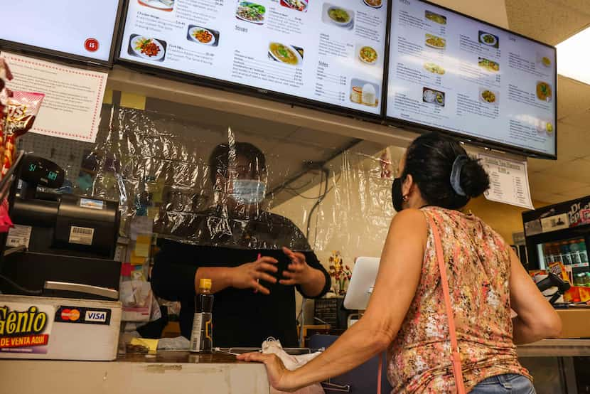 Phillip Southammavong assists a customer at the Ly Food Market in Oak Cliff.