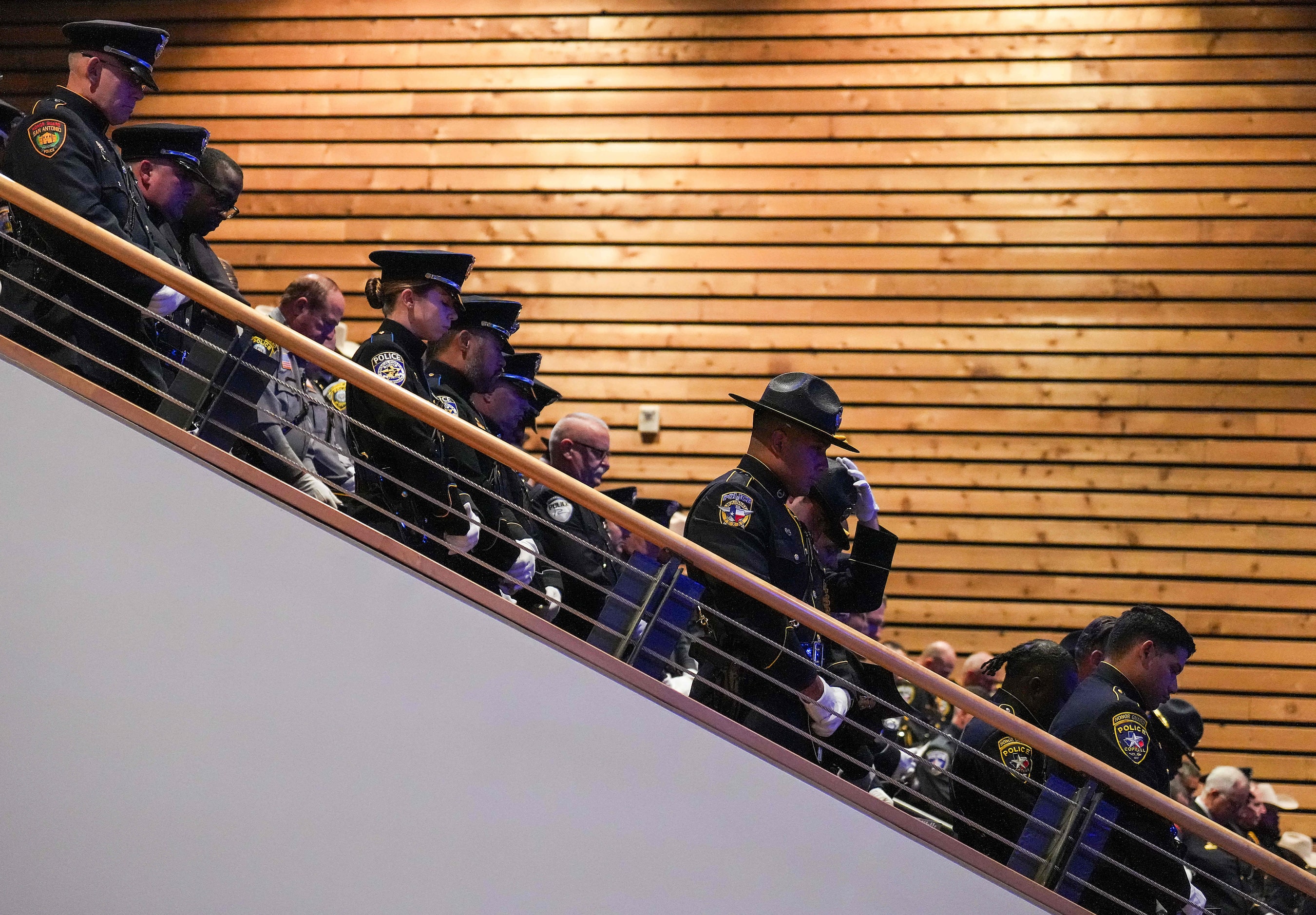 Law enforcement officers from around the state and the nation stand in prayer during funeral...