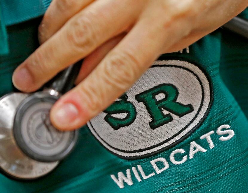 
A stethoscope checks the heartbeat of a Wildcat. Assistant coach Mark Bachtel wears his...