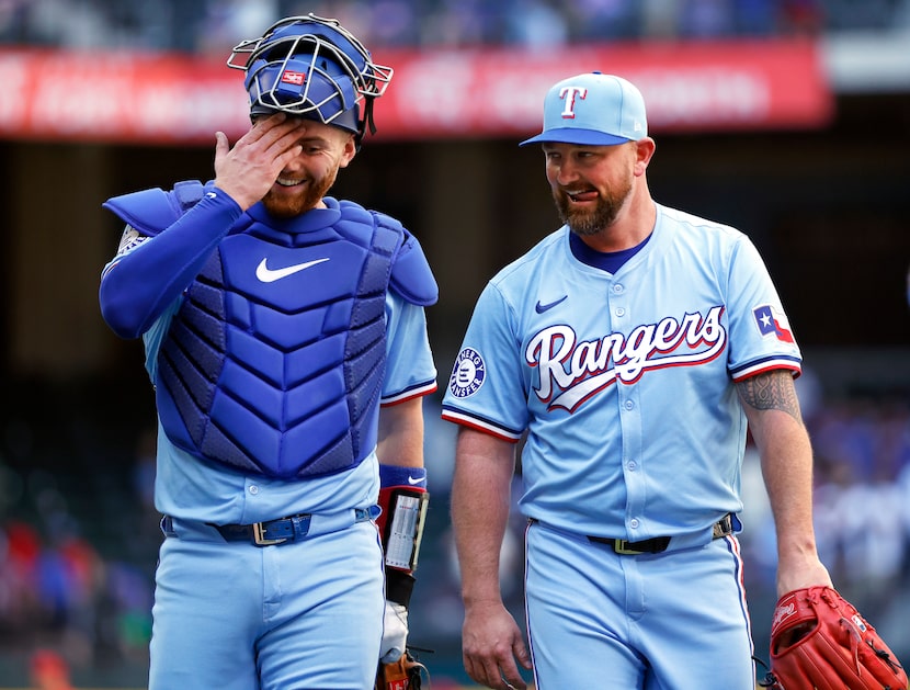 Texas Rangers catcher Carson Kelly (left) and relief pitcher Kirby Yates laugh together...