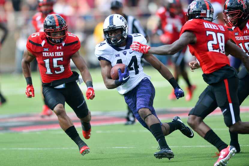 LUBBOCK, TX - SEPTEMBER 26: Jarrison Stewart #14 of the TCU Horned Frogs runs between Keenon...