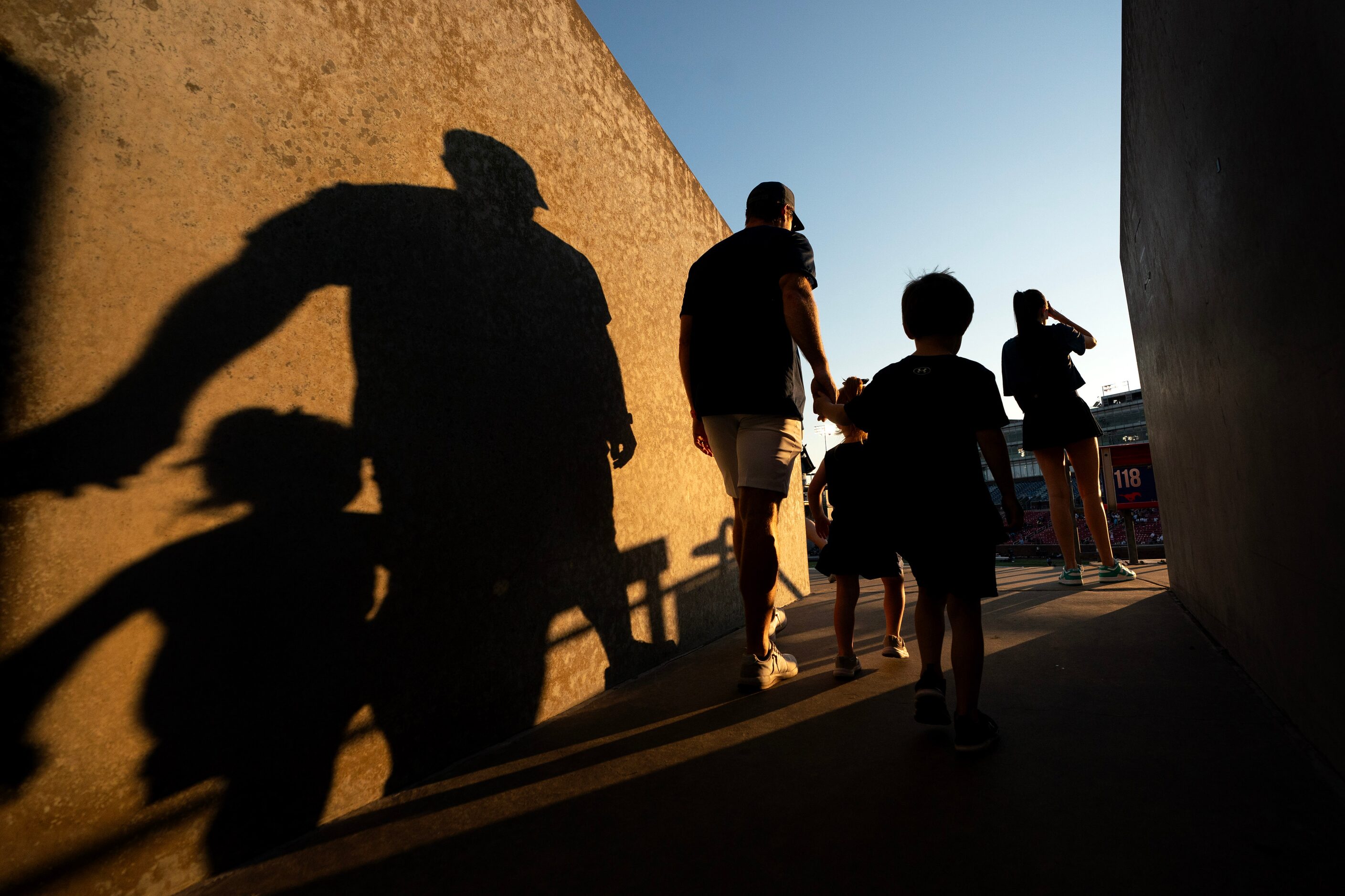 Highland Park fans cast long shadows as they enter Gerald J. Ford Stadium before a high...