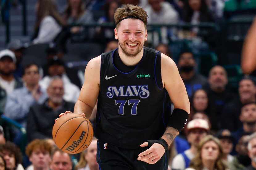 Dallas Mavericks guard Luka Doncic (77) smiles as he dribbles the ball during the first half...