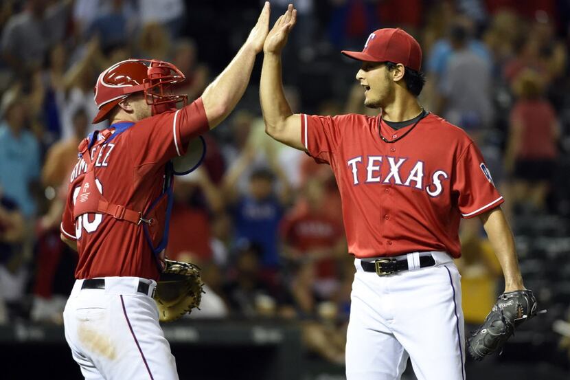 Texas Rangers catcher Chris Gimenez (60) and starting pitcher Yu Darvish (11) celebrate...