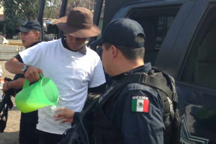 Leonardo Quintero, a member of a local self-defense force, pours lemonade for a federal...