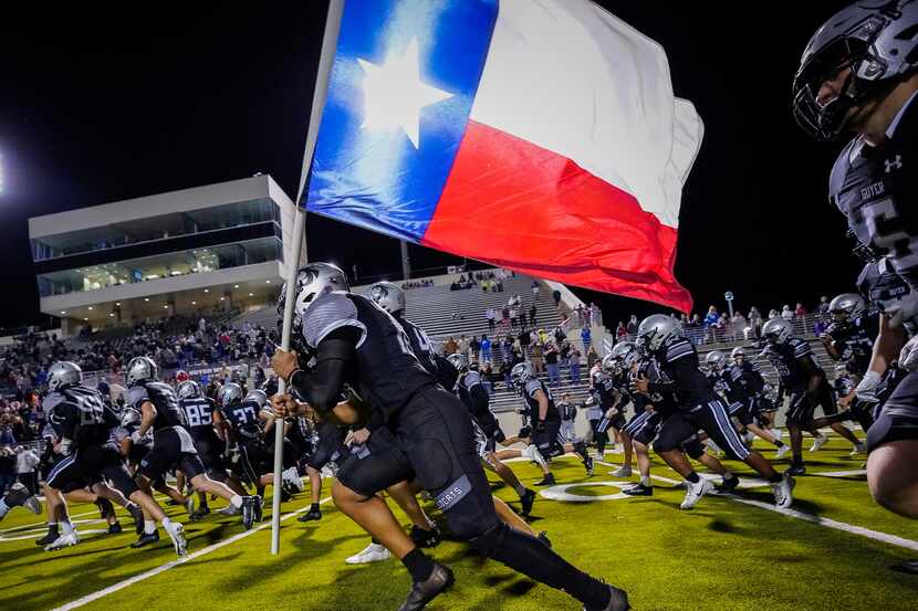 Denton Guyer linebacker Leo Gibbs (10) carries the Texas flag as the Wildcats take the field...