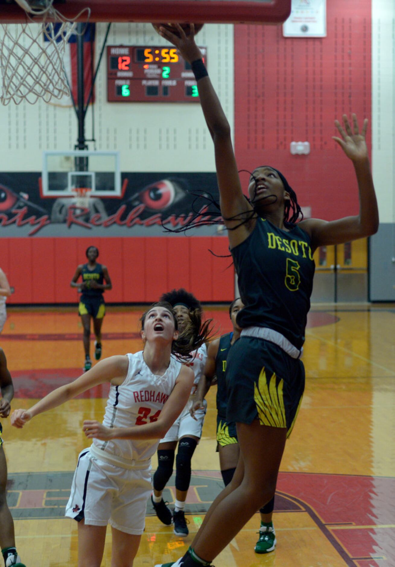 DeSoto's Sa'Myah Smith (5) goes up for a layup over Liberty's Maya Jain (24) in the first...