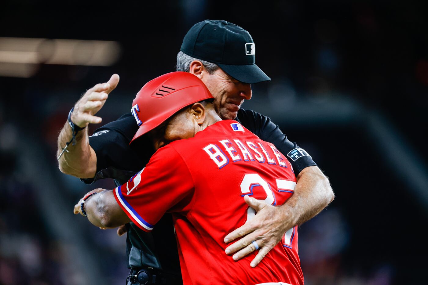 Texas Rangers third base coach Tony Beasley (27) hugs umpire Angel Hernandez (5) before the...