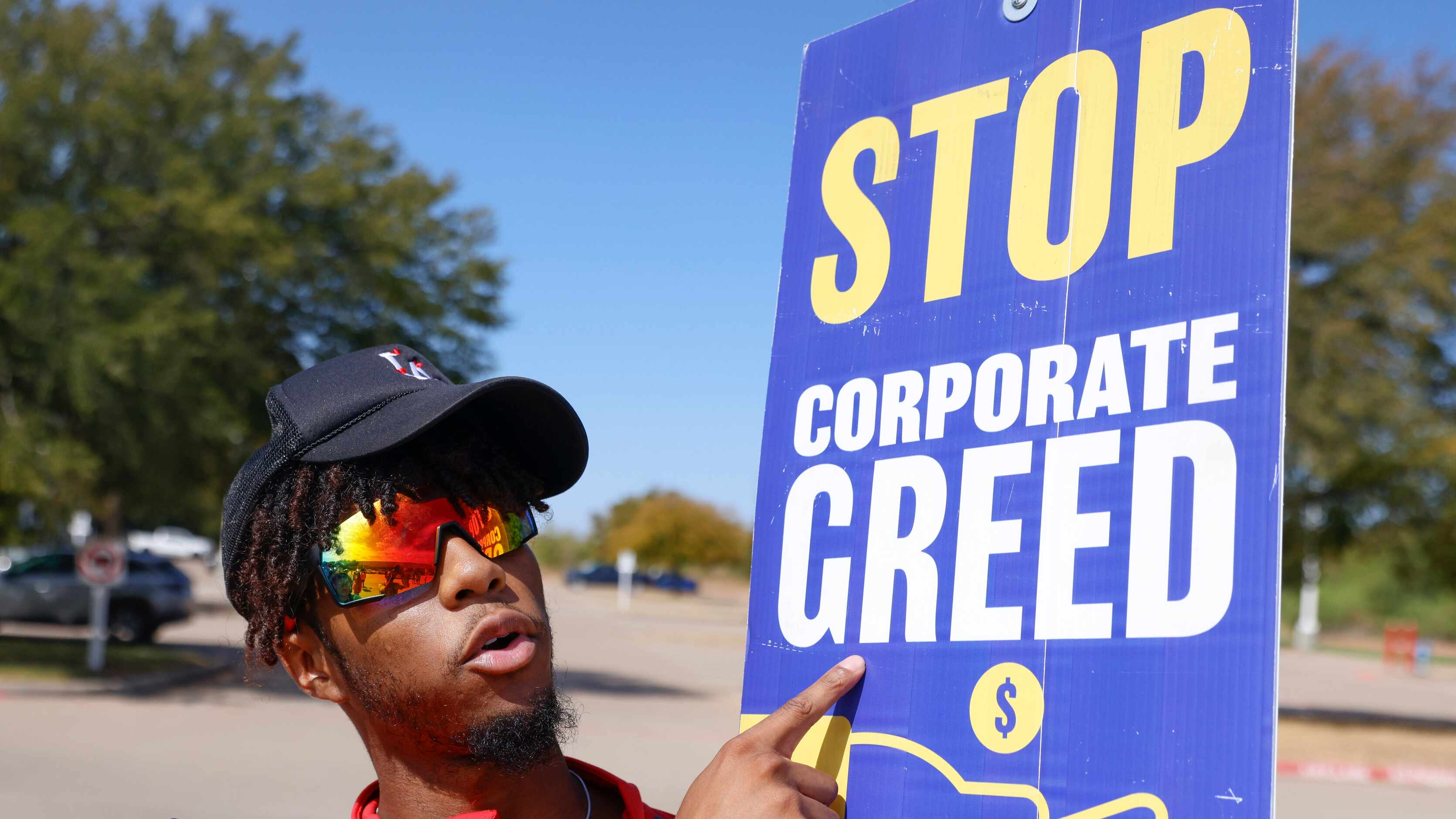 Warehouse associate Tylan Loston points towards the sign during a strike on Friday, Sept....