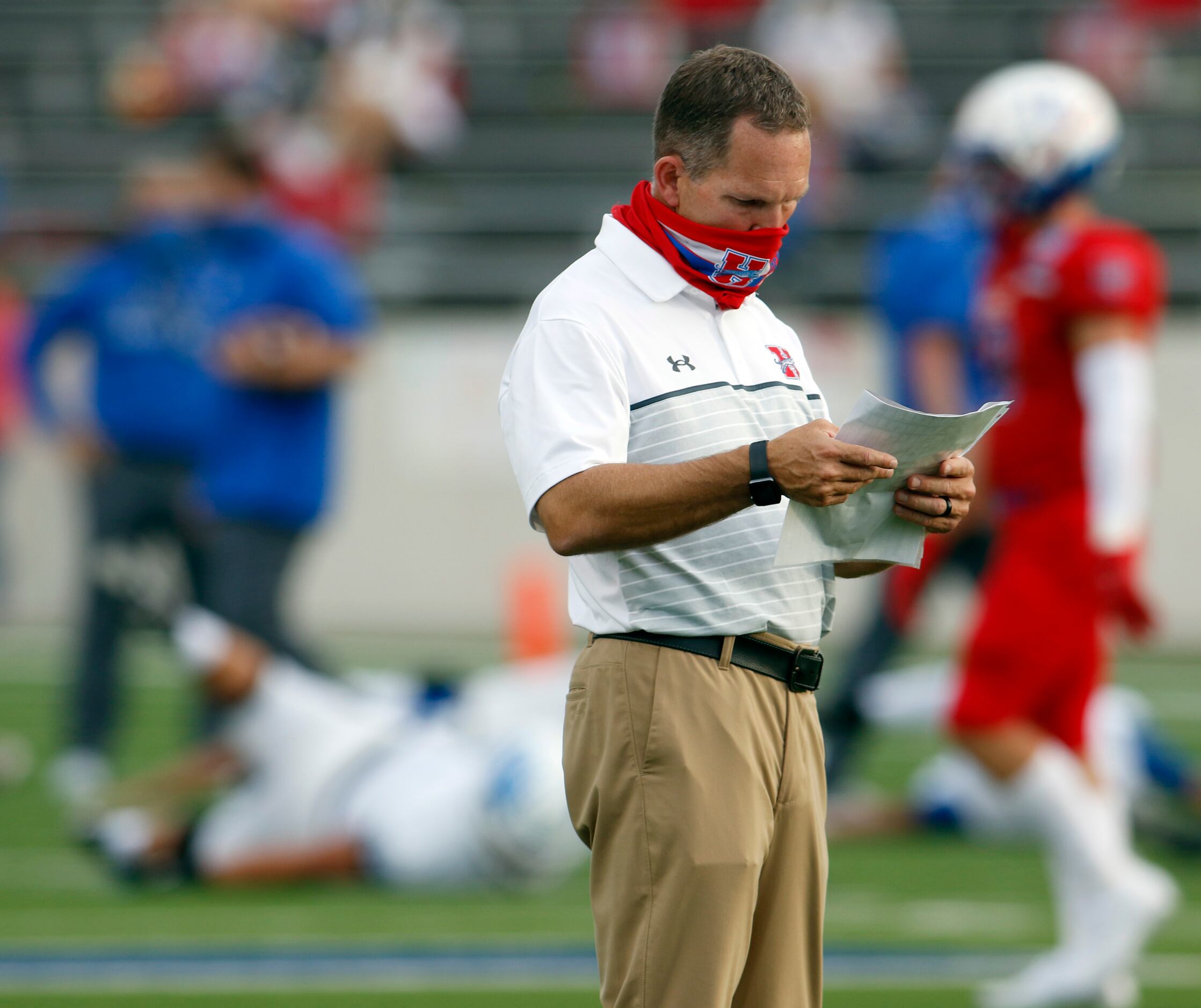 Midlothian Heritage head football coach Lee Wiginton visually peruses his play card during...