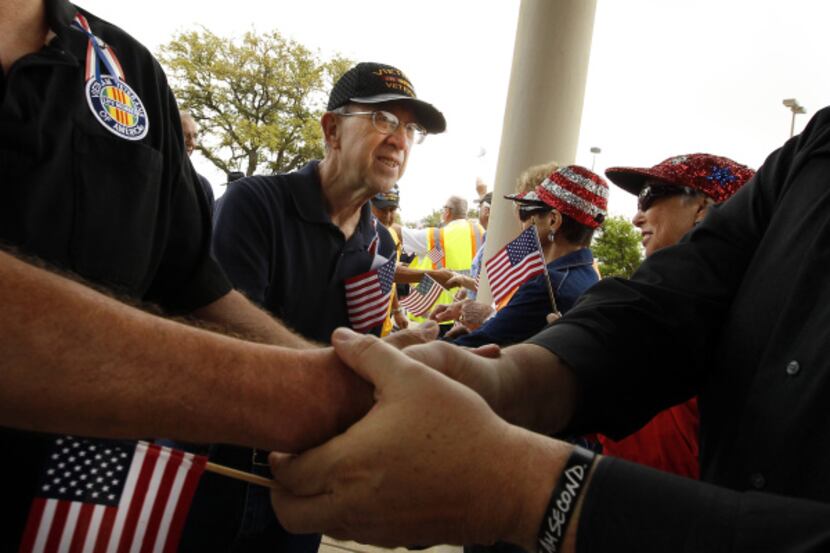 Vietnam veteran Jimmy Mauldin of Grand Prairie shook hands with Karelin Seitz  as veterans...