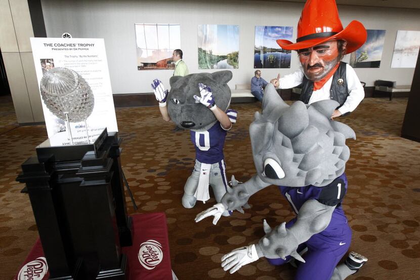 Kansas State, TCU and Oklahoma State mascots pay homage to The Coaches Trophy as they mess...