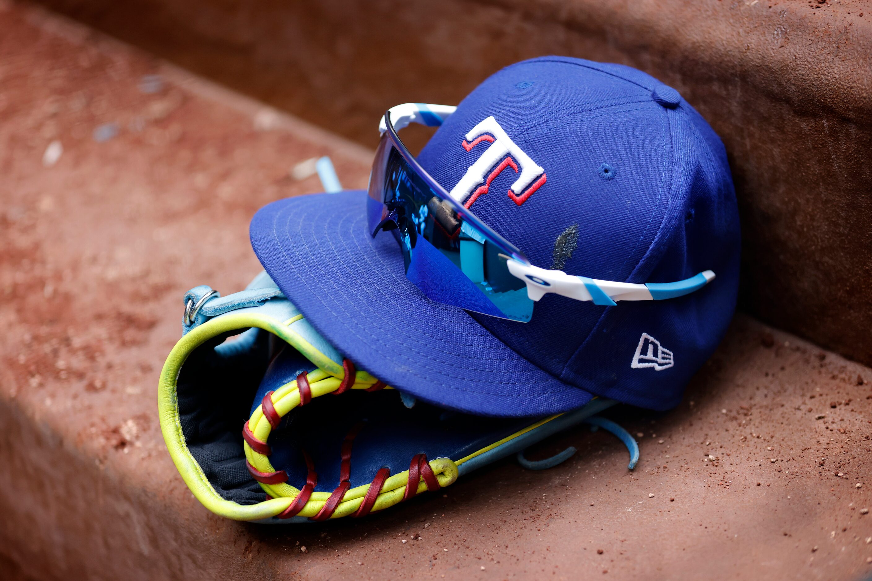 Texas Rangers Adolis Garcia's hat, glove and mitt sit on the dugout steps after their 12-7...