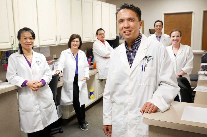 Dr. Stephen Buksh (foreground), a Euless doctor for 21 years, is pictured with fellow...