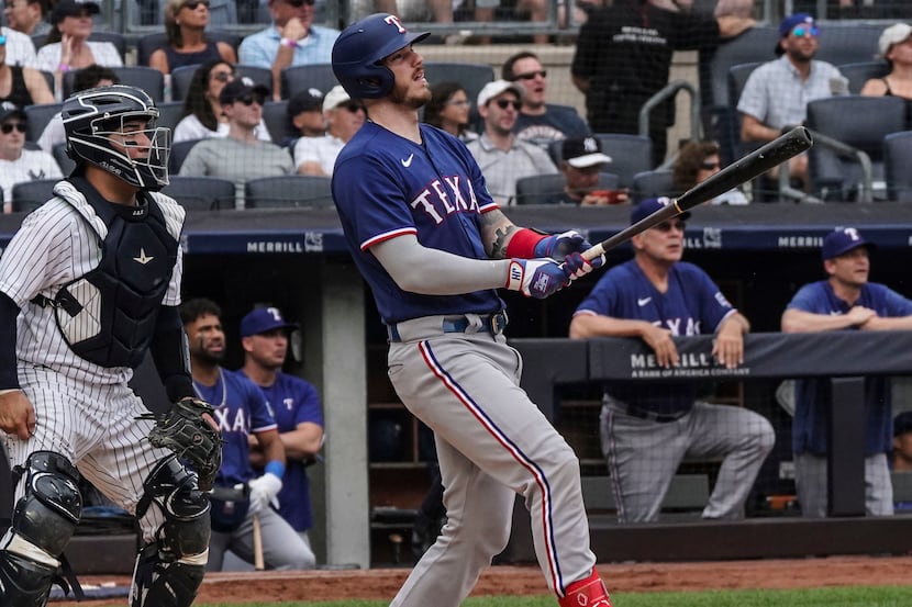 Texas Rangers' Jonah Heim watches his solo homer in the second inning of a baseball game...