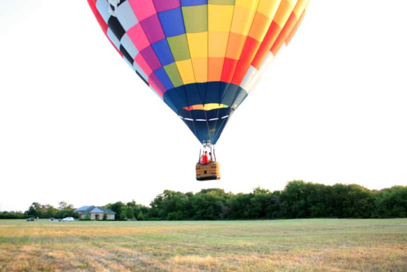 Luc and Loren Goethals' hot air balloon nicknamed "Zipper" takes off from a field in...