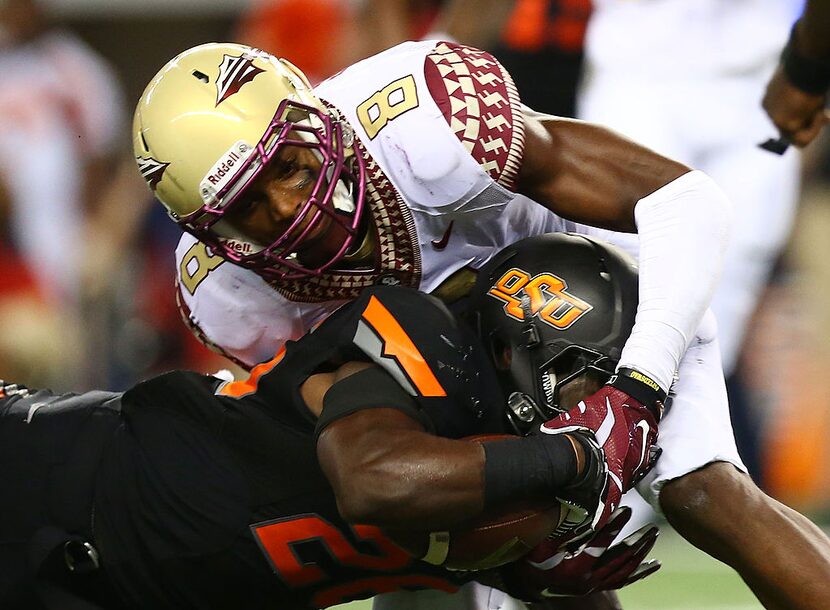 ARLINGTON, TX - AUGUST 30:  Desmond Roland #26 of the Oklahoma State Cowboys is tackled by...