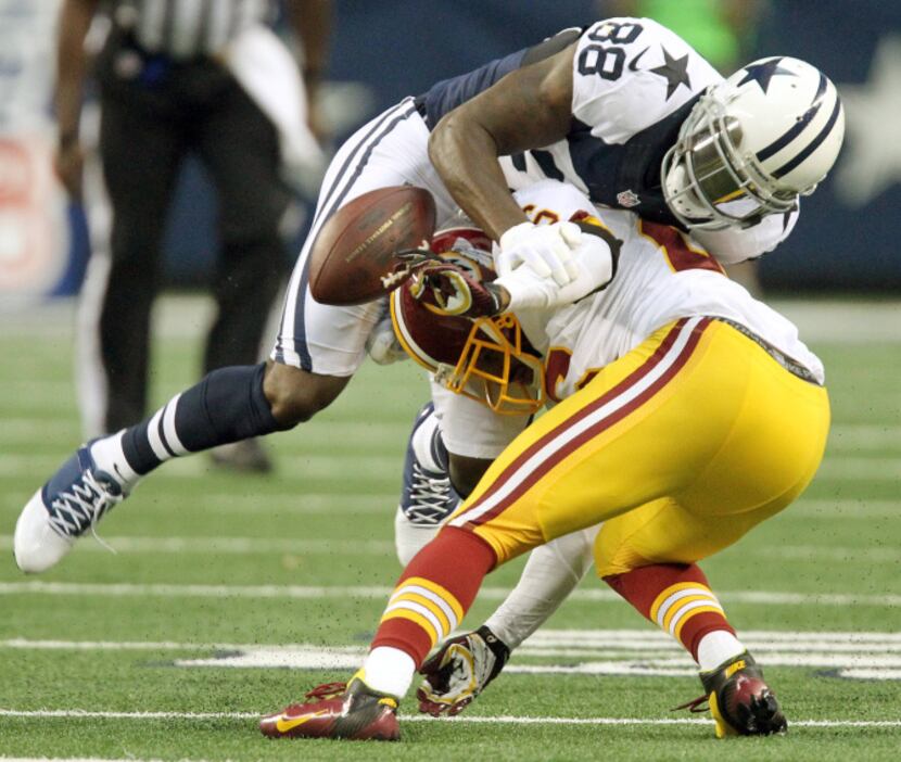 Dallas wide receiver Dez Bryant (88) fumbles after catching a pass, on a hit by Washington's...