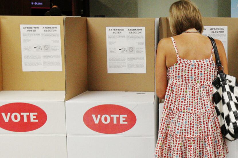 A lone voter in a voting booth marks her ballot at Precinct 111 in Oklahoma City last month...