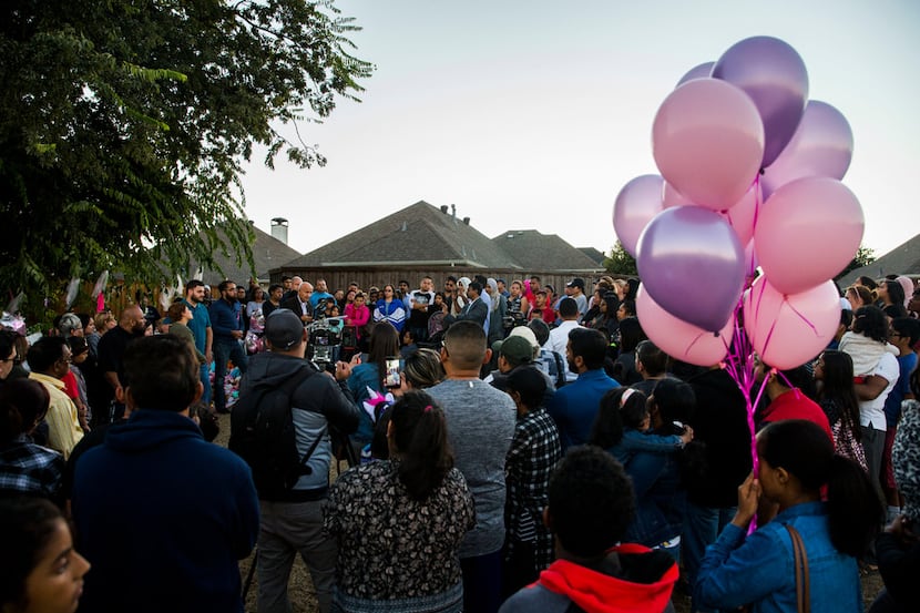 People gather at a memorial for missing 3-year-old Sherin Mathews on Oct. at a tree behind...