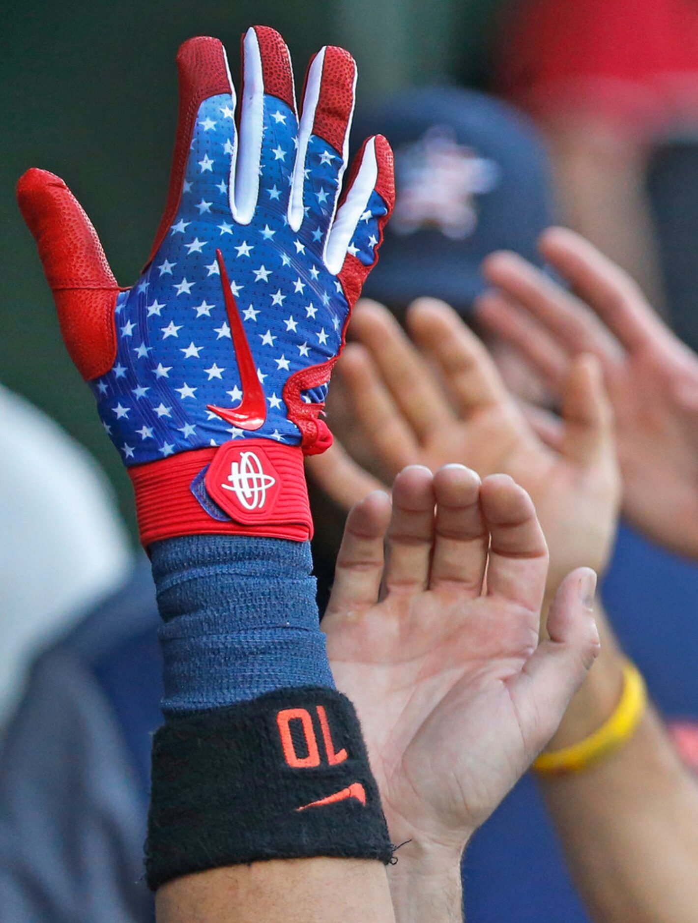 Houston Astros Yuli Gurriel (10) gives a star-spangled high fiv e to teammates in the dugout...