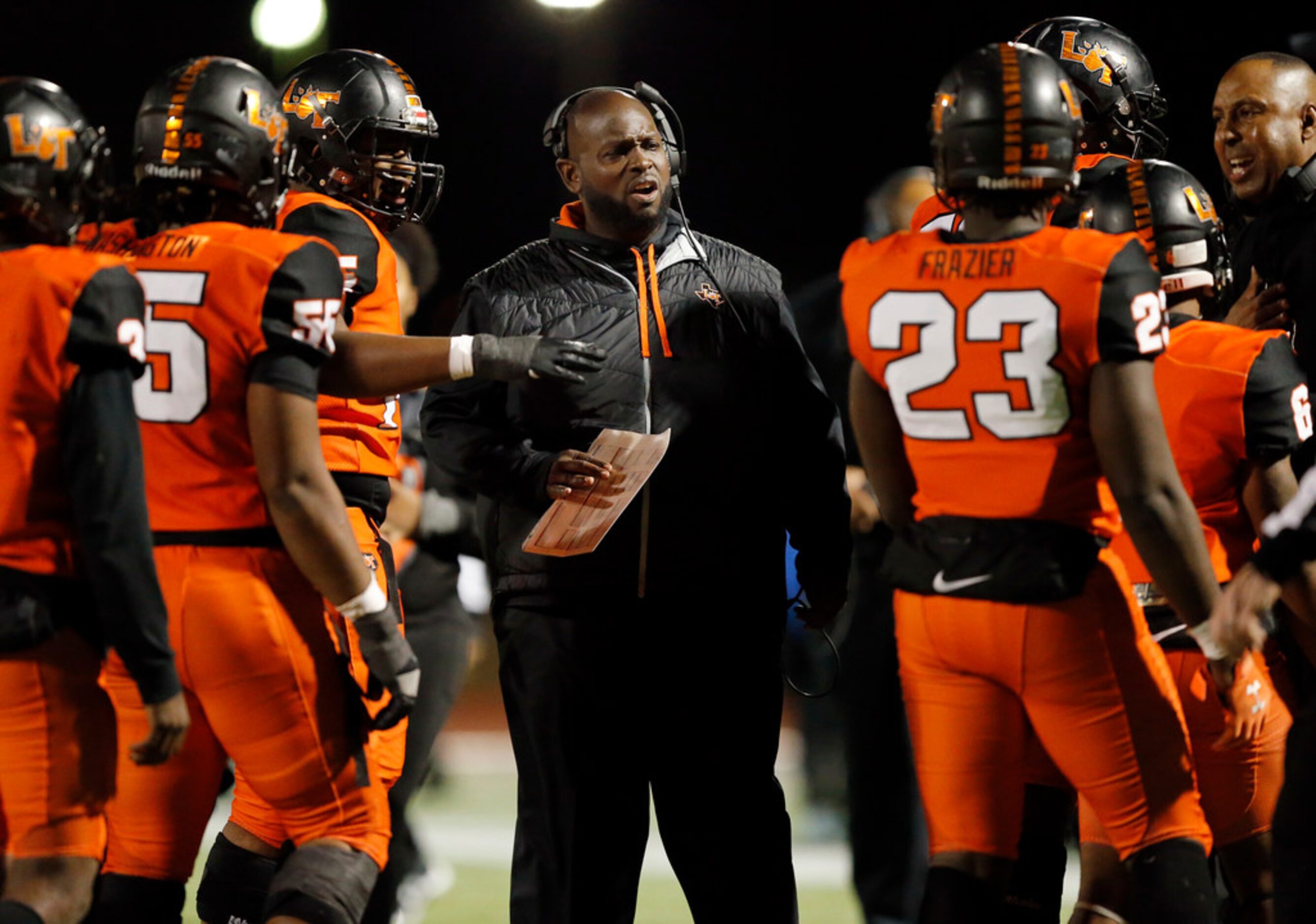 Lancaster head coach Chris Gilbert visits with his players during a first half timeout...