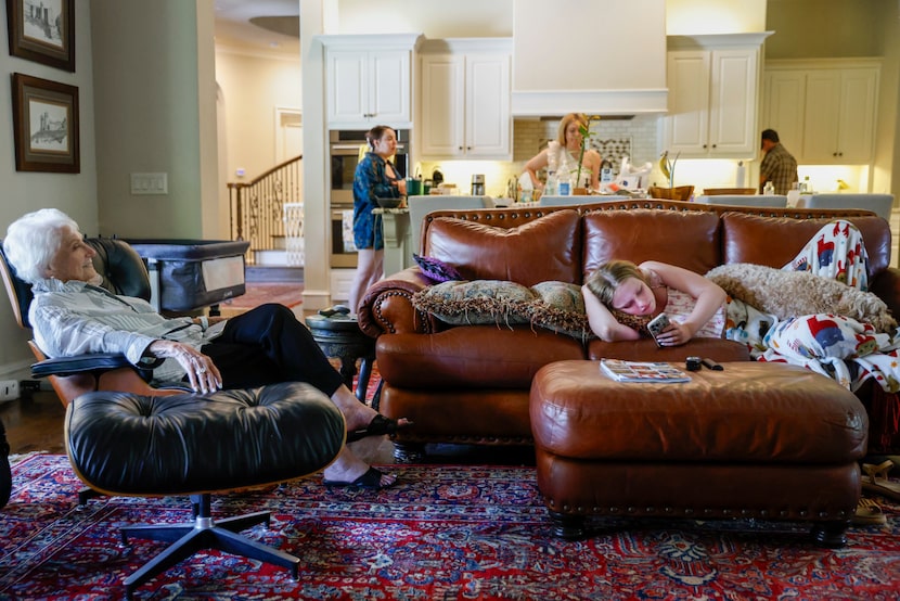 Clay's mother, JoAnn, (left) sits in the family room while his daughter Madeleine scrolls...