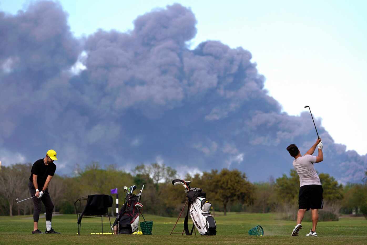Golfers practiced at the Battleground Golf Course driving range as a chemical fire at...