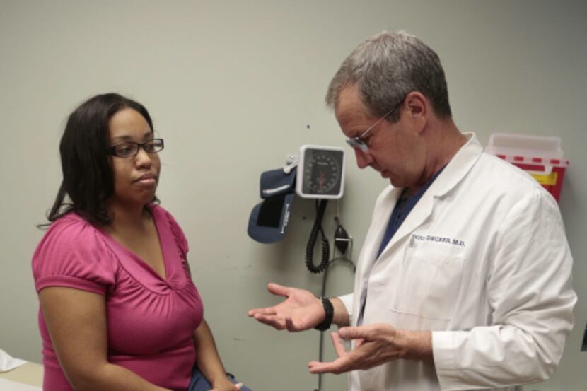 Dr. Douglas Decker prepares to perform acupuncture on Veronica Cooks , pregnant patient...