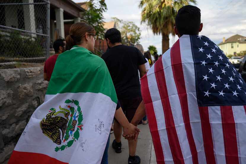 People wear Mexican and U.S. flags as hundreds marched to protest gun violence on Sunday...