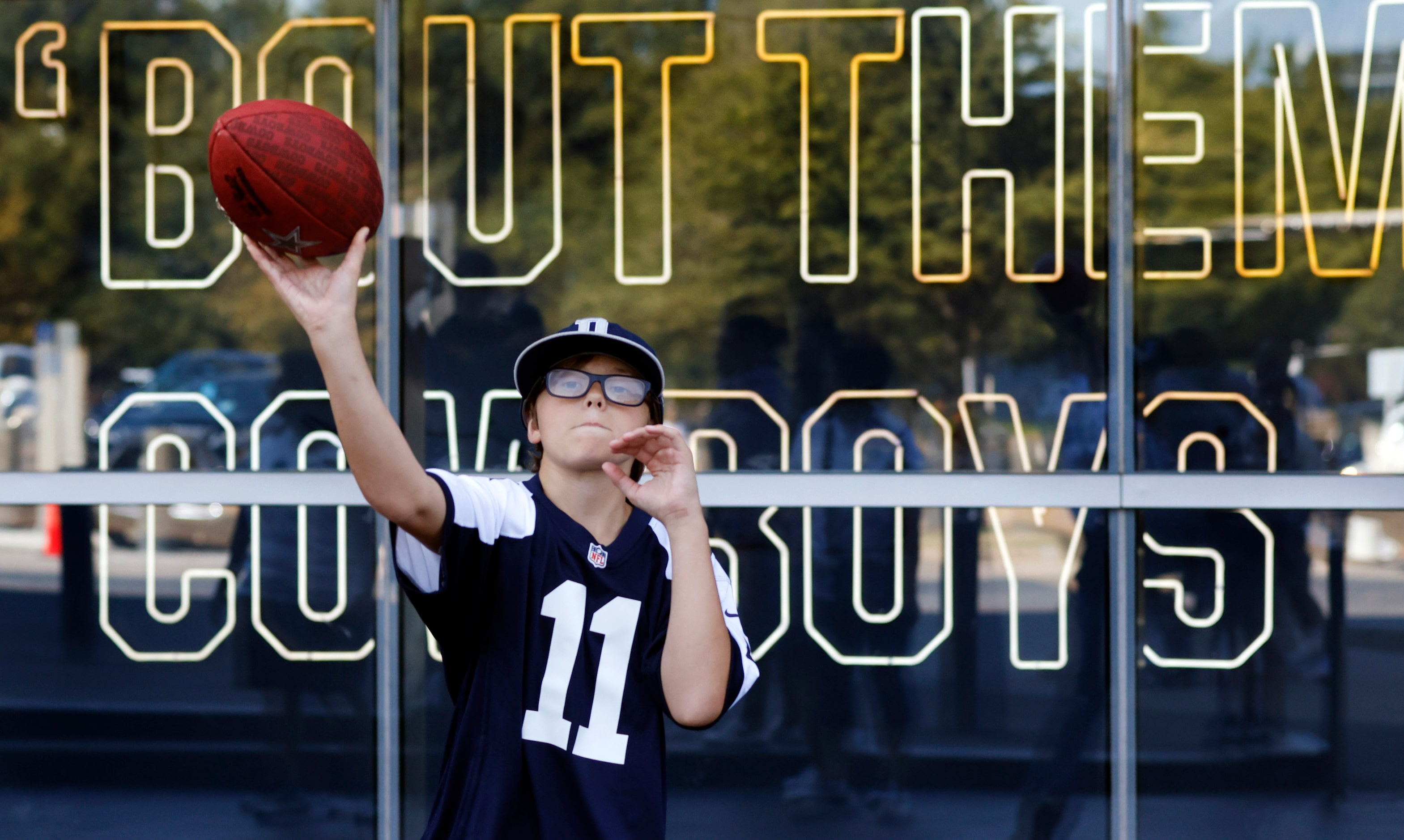 Dallas Cowboys fan Donald Powell Jr of Hazlehurst , Georgia tosses a pass to his cousin as...