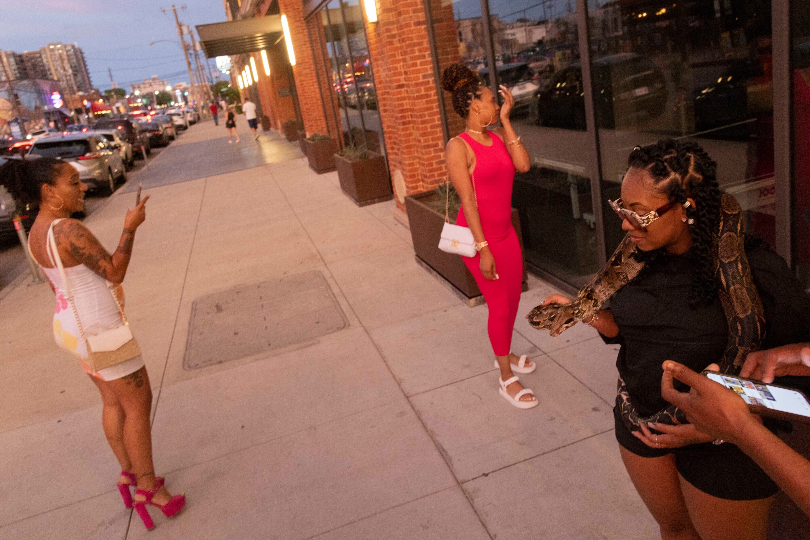 Nay Gibson (right) holds a snake handled by Clyde Gaines as her friends Catherine Gist...