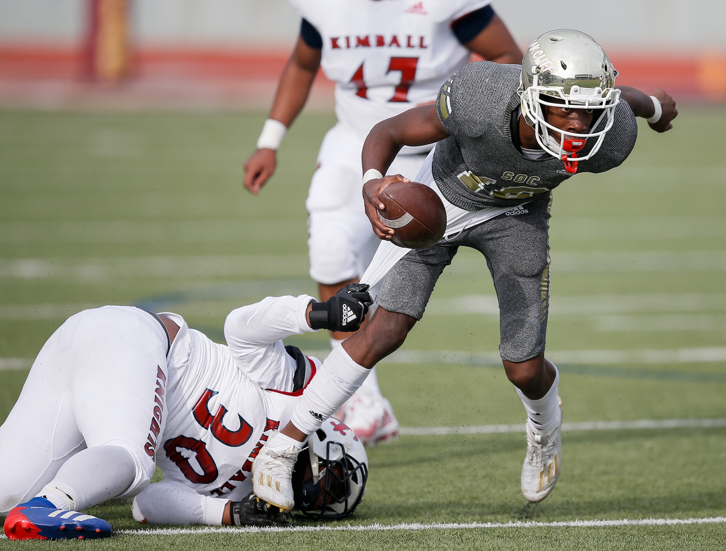 South Oak Cliff junior quarterback Kevin Henry-Jennings (10) tries to escape Kimball senior...