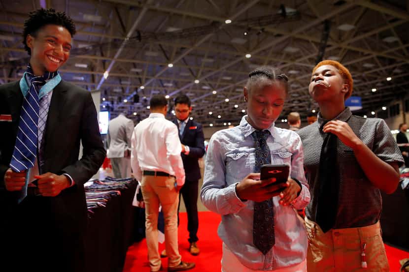 Tykia Evans of Dallas (right) takes pride in his tie he learned how to put on during the...