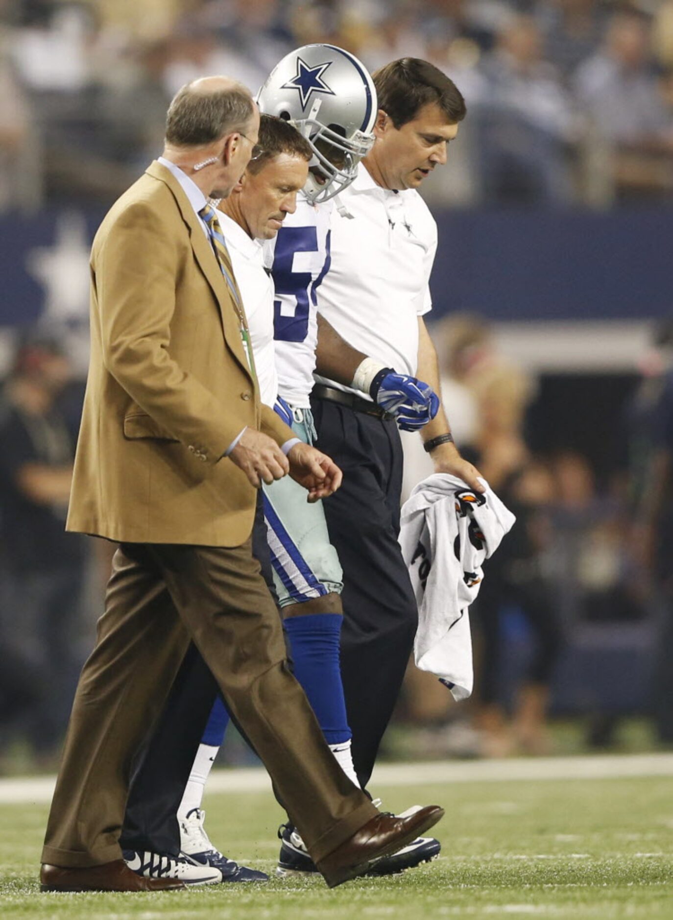 Dallas Cowboys outside linebacker Bruce Carter (54) is helped off the field by medical staff...