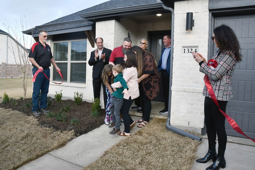 Veteran U.S. Army Specialist John Endsley and his family celebrate receiving the keys to...