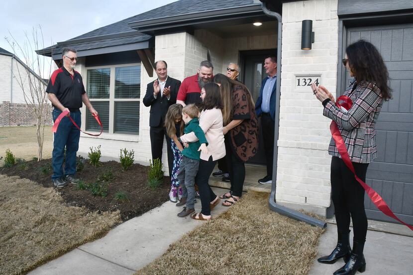 Veteran U.S. Army Specialist John Endsley and his family celebrate receiving the keys to...