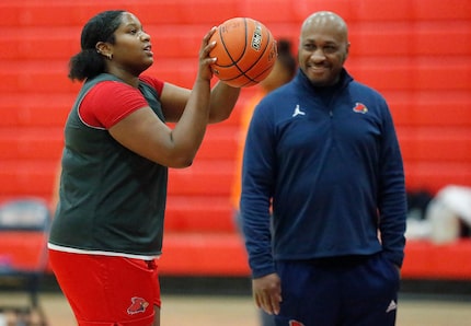 Taylor Haggan, forward for John Paul II High School in Plano, shoots free throws in front of...