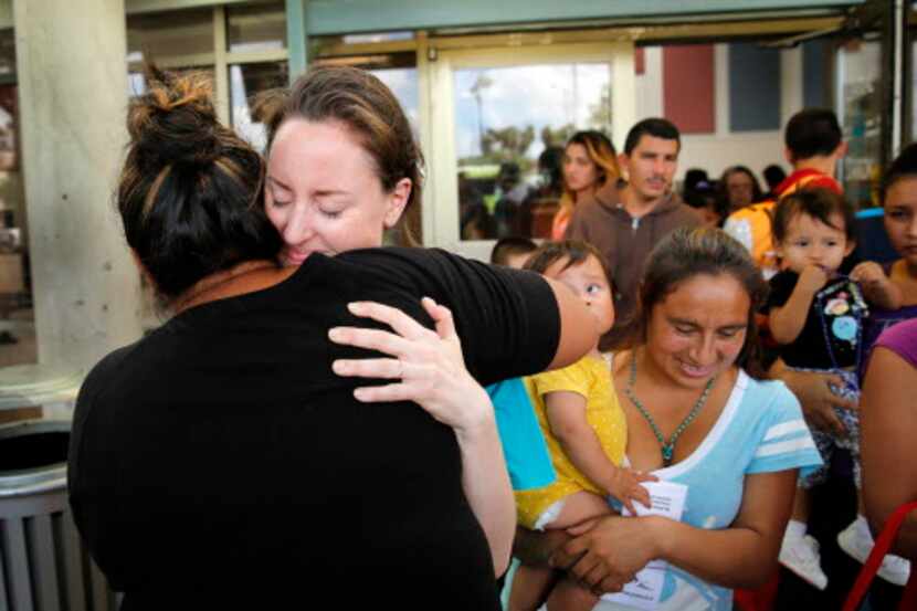 La voluntaria Claire Scoville recibe un abrazo de una madre hondureña en la estación de...