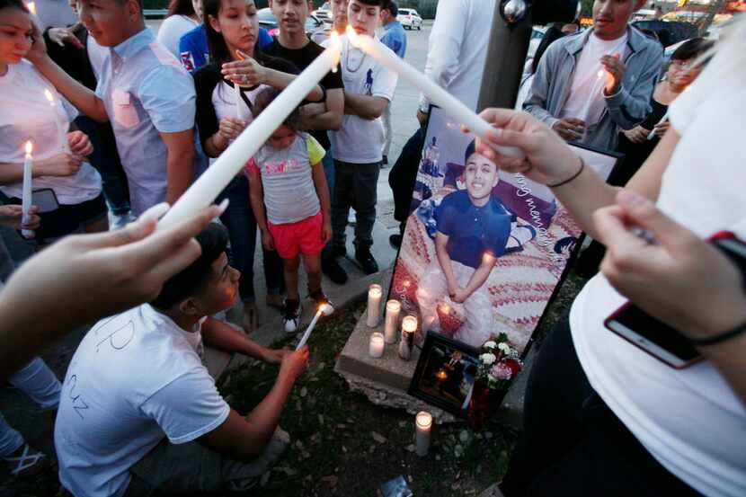  Armando Monsalve, 15, kneels in front of a portrait of longtime friend Jose Cruz, 16,...