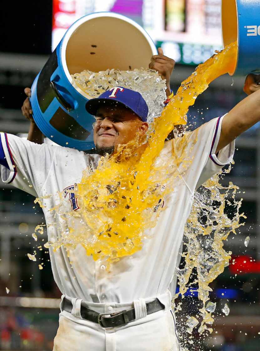 Rangers left fielder Carlos Gomez (14) gets doused by second baseman Rougned Odor (12) and...